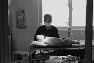 Cina, 102-044-00
Un medico assiste un bambino su un letto, 2007
Ospedale Civile, Siyang (Cina)