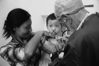Cina, 102-038-28
Un medico controlla un bambino in braccio alla madre, 2007
Ospedale Civile, Siyang (Cina)