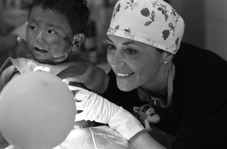 Tibet, 102-022-08
Un'infermiera sorride accanto a un bambino con una profonda ferita sulla guancia, 2004
Shigatse (Tibet)