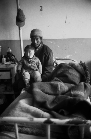 Tibet, 102-019-24
Un bambino operato al volto siede in braccio al padre su un letto di ospedale, 2004
Shigatse (Tibet)