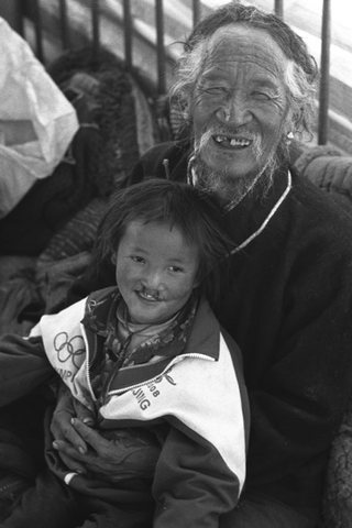 Tibet, 102-017-18 Un uomo e il nipote seduti per terra sorridono, 2004 Shigatse (Tibet)