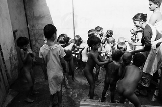 Bangladesh, 103-042-29
Dei bambini vengono lavati all'aperto da una ragazza e un ragazzo, 2009
Associazione Tokai Songho, Dacca (Bangladesh)