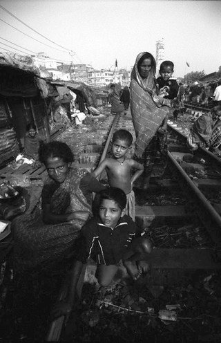 Bangladesh, 103-043-02
Donne e bambini dello slum sulla ferrovia siedono e camminano sui binari, 2009
Dacca (Kawran Bazar) (Bangladesh)