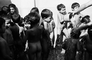 Bangladesh, 103-042-25
Bambini nudi vengono lavati con secchi d'acqua all'aperto, 2009
Associazione Tokai Songho, Dacca (Bangladesh)