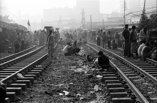 Bangladesh, 103-042-11
Abitanti dello slum sulla ferrovia camminano e si siedono sui binari, 2009
Dacca (Kawran Bazar) (Bangladesh)