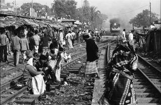 Bangladesh, 103-042-18
Abitanti dello slum sulla ferrovia camminano e si siedono sui binari dopo il passaggio di un treno, 2009
Dacca (Kawran Bazar) (Bangladesh)