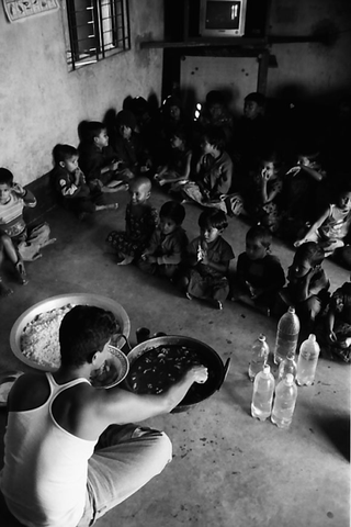 Bangladesh, 103-037-03
Un uomo raziona il cibo per i bambini seduti davanti a lui nel rifiugio di Padre Riccardo Tobanelli, 2009
Associazione Tokai Songho, Dacca (Bangladesh)